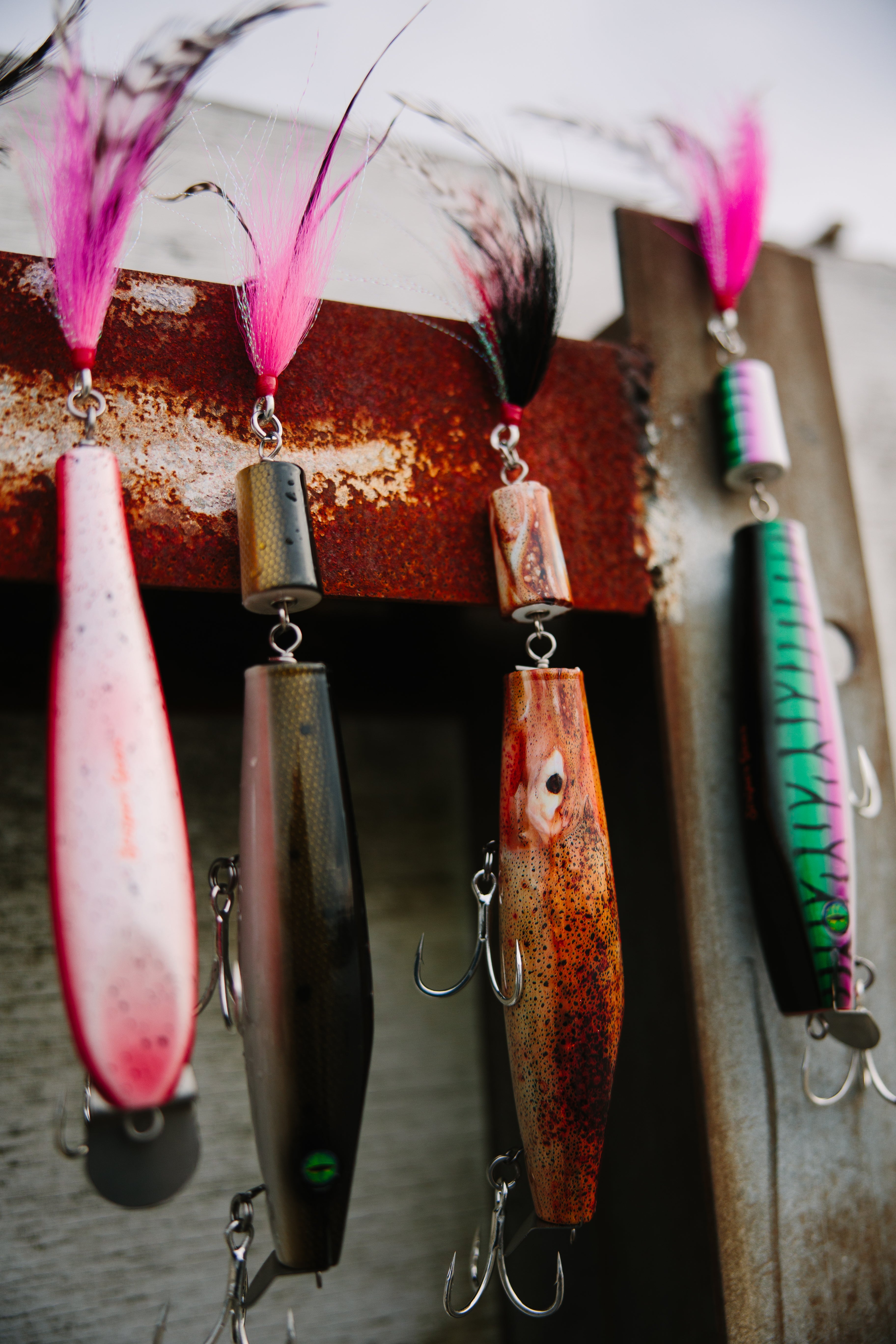 Collection of jointed fishing lures on a rusty metal beam.